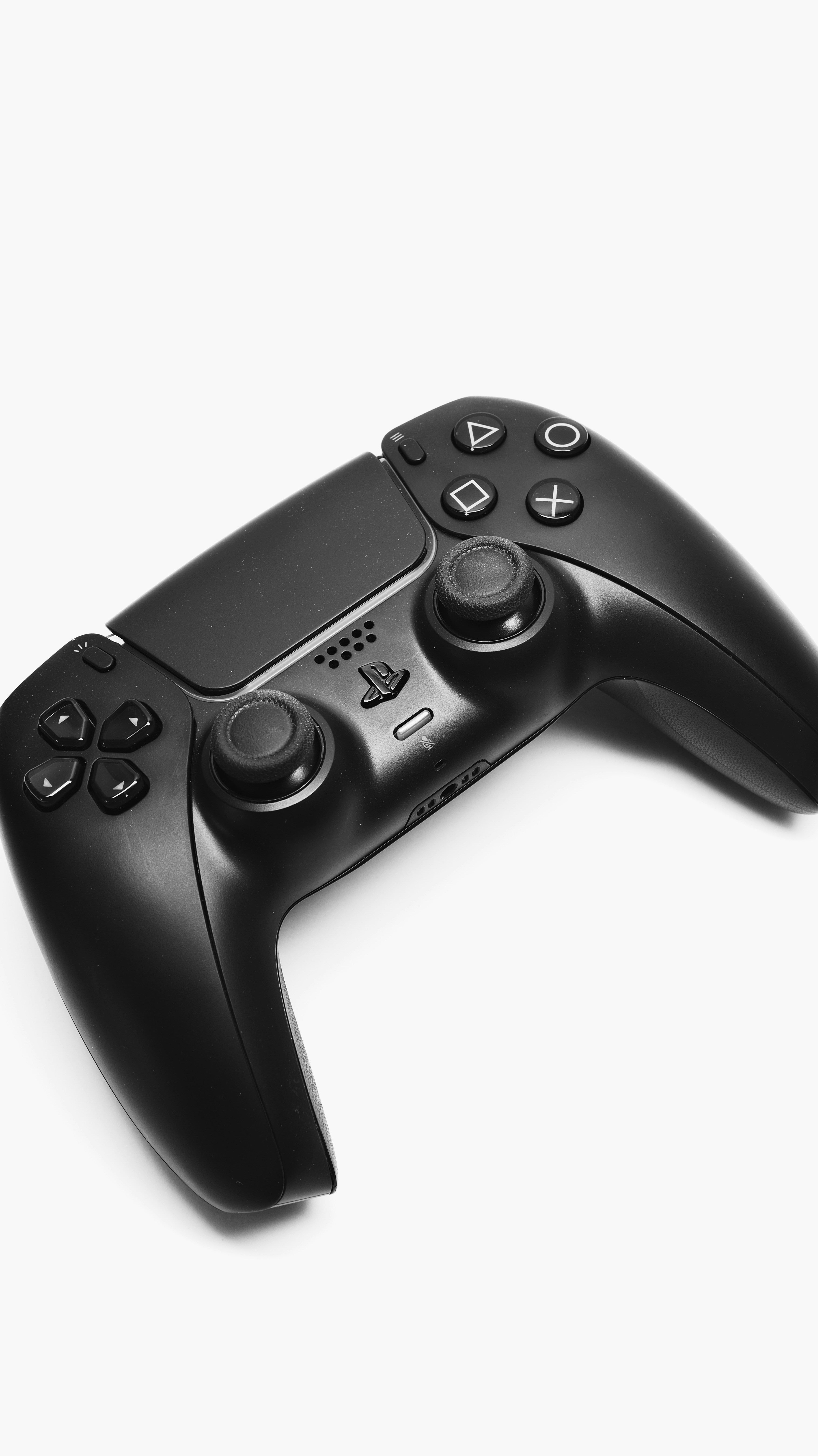 Black gaming controller on a white background